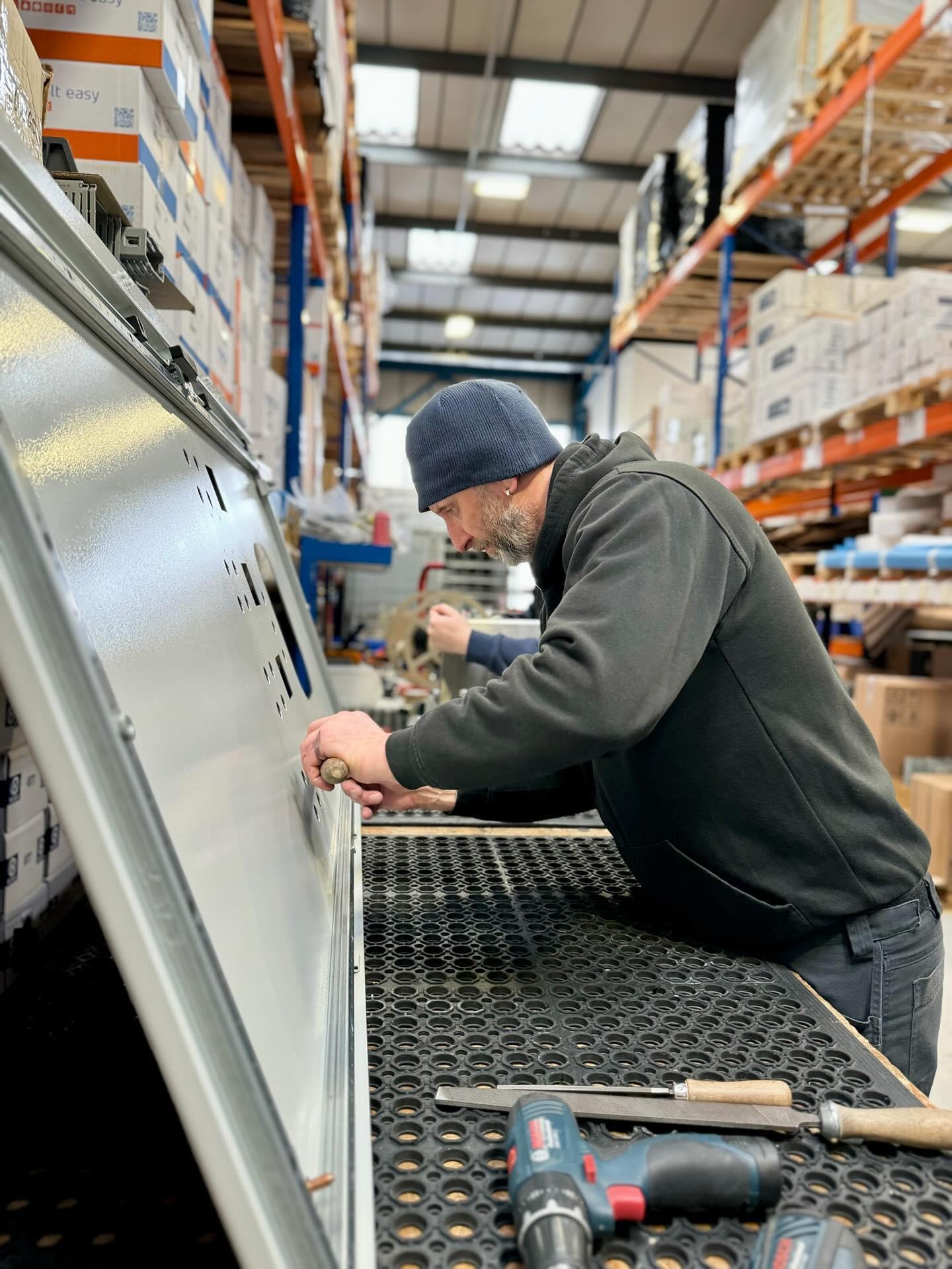 A member of the Modifications Team filing an enclosure that's been cut